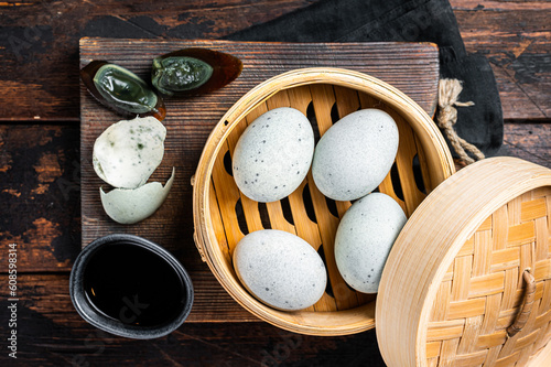 Black Century eggs, preserved duck egg, Chinese cuisine. Wooden background. Top view