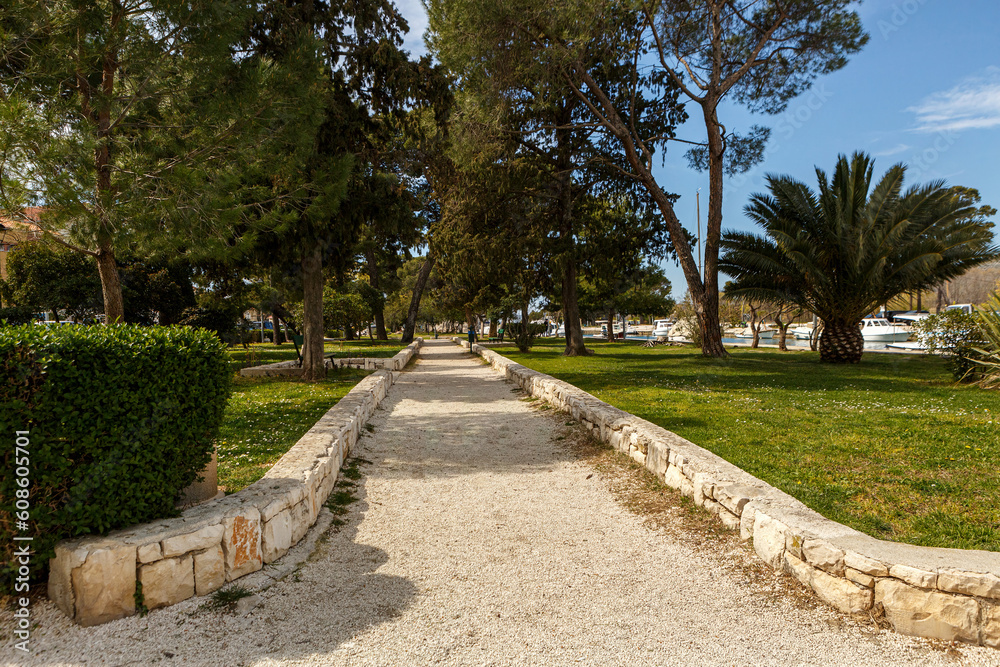 View at a path in a public pedestrian park in Trogir, Dalmatia, Croatia, in early spring