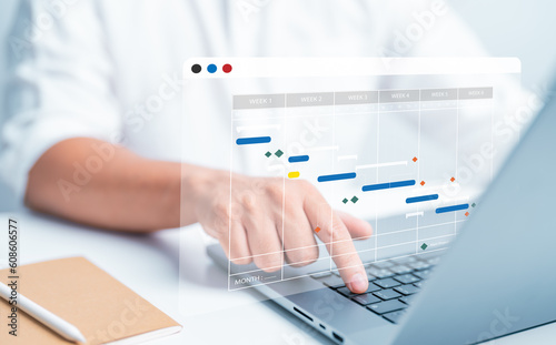 Project management or Site engineer makes proceeding report concept. Plant manager use planning software to generate Gantt chart schedules for updating construction progress and operations plan tasks. photo