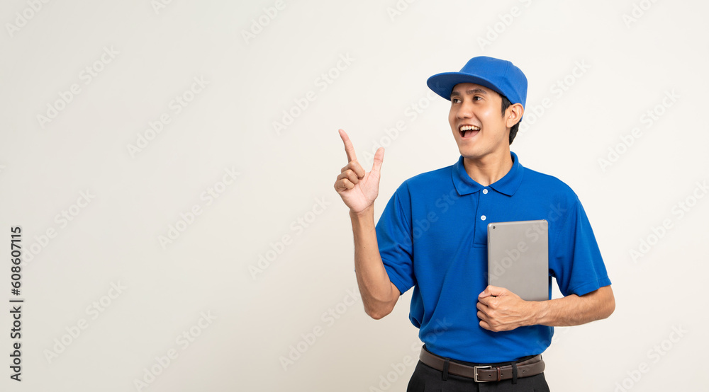 Asian man in blue uniform standing holding digital tablet computer on isolated white background. Male service worker with cell phone. Delivery courier shipping service Asian man in blue uniform standing holding digital tablet computer on isolated white background. Male service worker with cell phone. Delivery courier shipping service