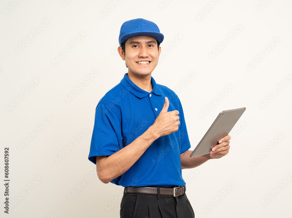 Asian man in blue uniform standing holding digital tablet computer on isolated white background. Male service worker with cell phone. Delivery courier shipping service Asian man in blue uniform standing holding digital tablet computer on isolated white background. Male service worker with cell phone. Delivery courier shipping service