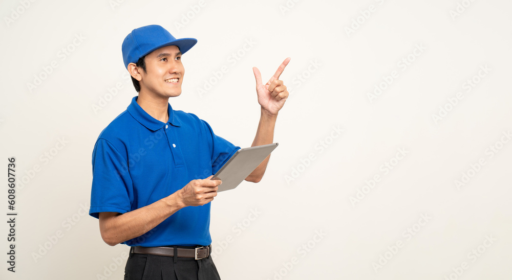 Asian man in blue uniform standing holding digital tablet computer on isolated white background. Male service worker with cell phone. Delivery courier shipping service Asian man in blue uniform standing holding digital tablet computer on isolated white background. Male service worker with cell phone. Delivery courier shipping service