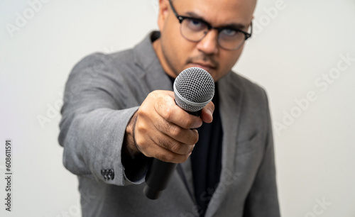 Businessman speaker with high quality dynamic microphone speaking talking with people on isolated white background. Male testing microphone voice for interview. Motivation life coach in training