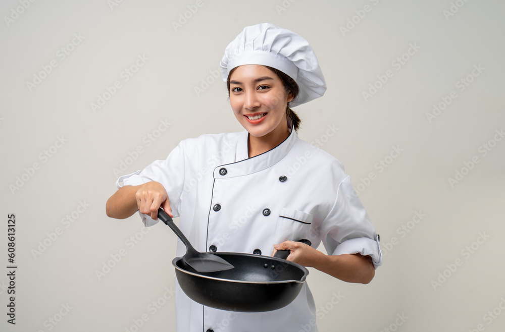 Young beautiful asian woman chef in uniform holding turner and iron Frying pan utensils cooking in the kitchen various gesture on isolated background. woman occupation chef restaurant and hotel. Young beautiful asian woman chef in uniform holding turner and iron Frying pan utensils cooking in the kitchen various gesture on isolated background. woman occupation chef restaurant and hotel.
