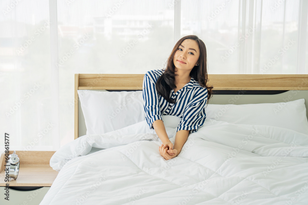 Photo of pretty joyful woman in pajama underneath the quilt looking camera and smiling while lying on bed after sleep or nap. Photo of pretty joyful woman in pajama underneath the quilt looking camera and smiling while lying on bed after sleep or nap.