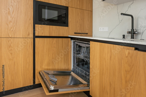 Quadro su tela Modern kitchen with empty Built-in dishwasher with opened door, Stainless steel