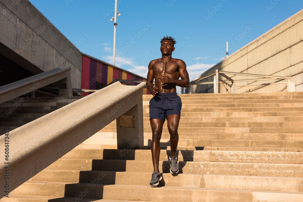 Fitness training outdoors. Handsome African man running. Muscular man training.