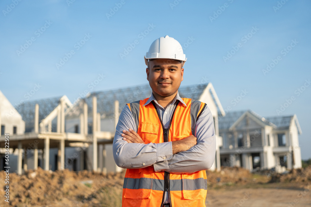 Confident engineer handsome man at modern home building construction. Architect with white safety helmet at site. Real Estate building under construction. Foreman senior worker project designer Confident engineer handsome man at modern home building construction. Architect with white safety helmet at site. Real Estate building under construction. Foreman senior worker project designer