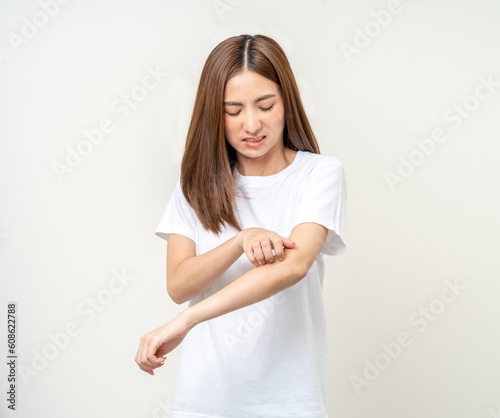 Asian women have skin problems She felt irritation on her skin. Skin infection itching red rash scratching with hands. She around 25 Wearing white shirt standing on isolate background photo