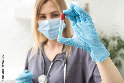 COVID-19 vaccine in researcher hands  female doctor s holds syringe and bottle with vaccine for coronavirus cure. Concept of corona virus treatment  injection  shot and clinical trial during pandemic.