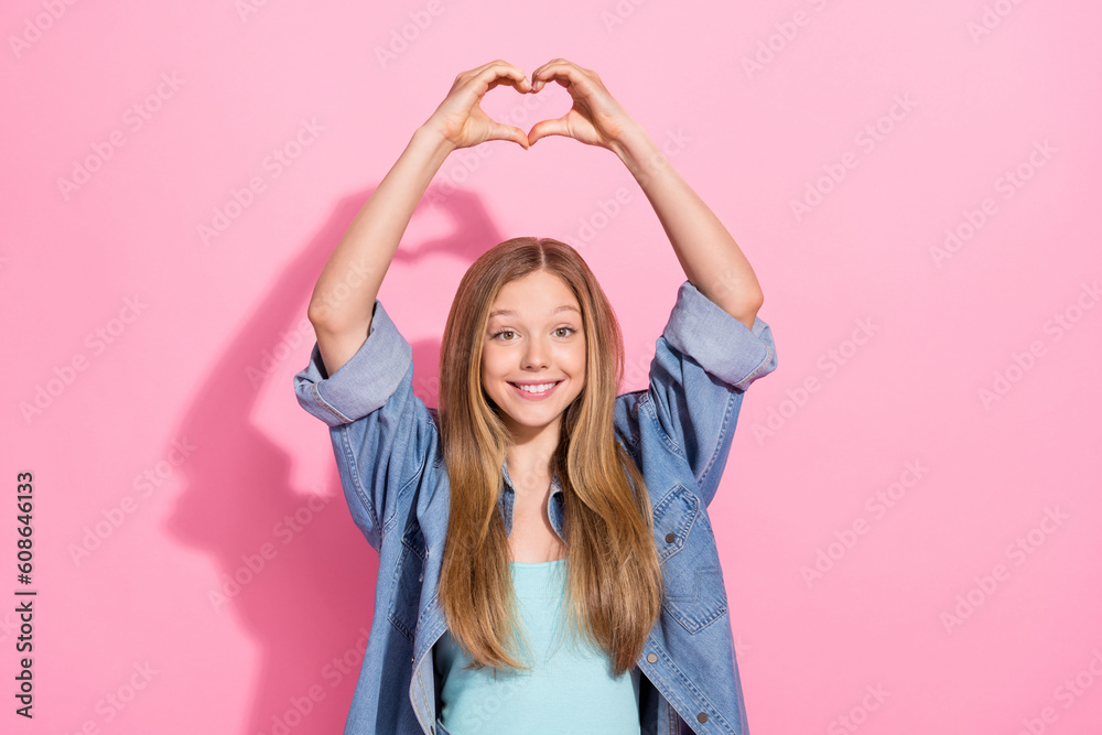 Photo portrait of lovely young teenager lady raise hands heart shape gesture wear trendy jeans garment isolated on pink color background Photo portrait of lovely young teenager lady raise hands heart shape gesture wear trendy jeans garment isolated on pink color background