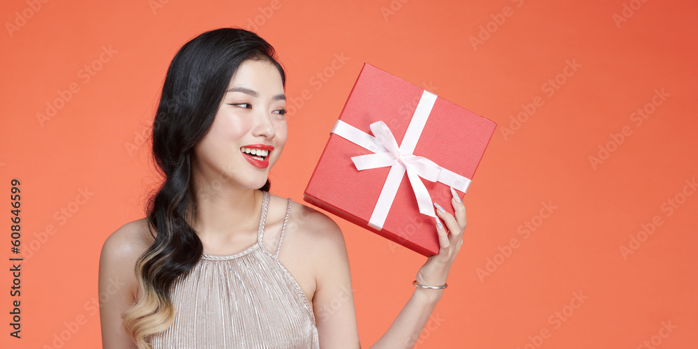 young girl with a beautiful wide smile holds a surprise gift for holiday in her hands young girl with a beautiful wide smile holds a surprise gift for holiday in her hands
