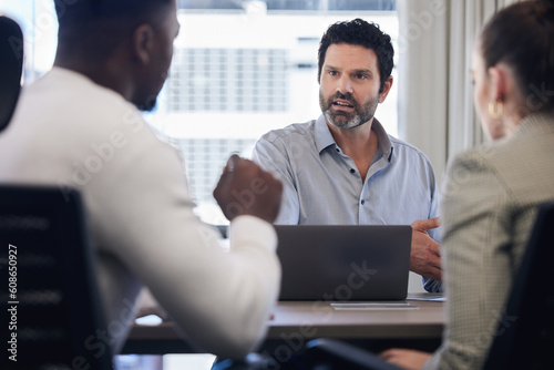 Meeting, management and a serious man in business talking to staff in his office at work for planning. Laptop, discipline and discussion with a male manager addressing a team in a corporate workplace