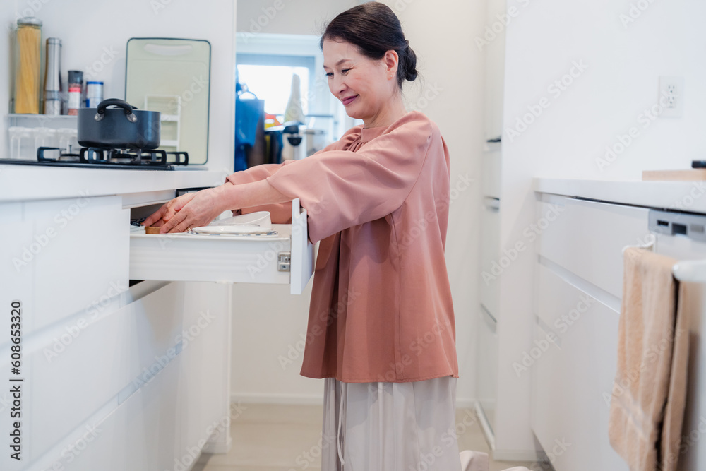 キッチンの収納を工夫するシニアの女性 キッチンの収納を工夫するシニアの女性