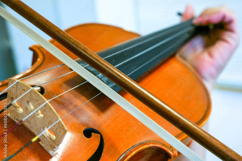 Primer plano de una alumna de violín tocando su instrumento en una clase de música. Primer plano de una alumna de violín tocando su instrumento en una clase de música.