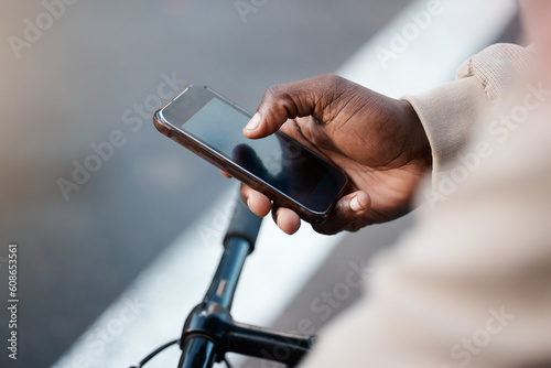 Man, hands and phone with screen on bicycle for social media, communication or networking on mockup in city. Closeup of male person typing or texting on bike with mobile smartphone in an urban town
