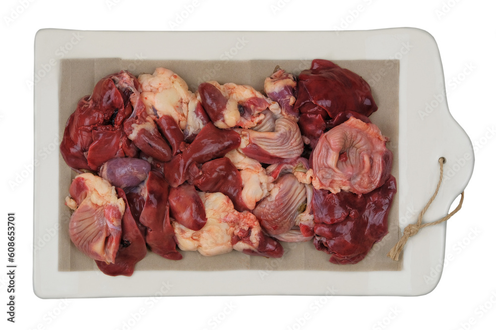 Raw chicken giblets on a ceramic board isolated on white background. Chicken stomachs, hearts and livers are prepared for cooking.