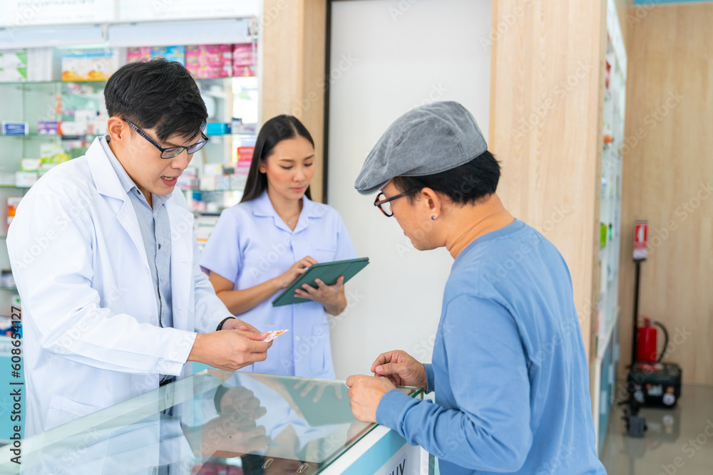 Obraz premium Medical pharmacy and healthcare providers concept. Professional Asian man and woman pharmacist recommend and selling medical product, medicine, drugs and supplements to patient customer in drugstore.
