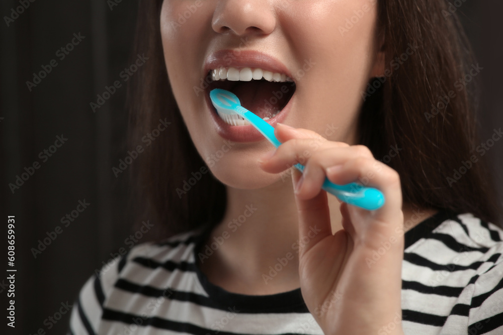 Woman brushing her teeth with plastic toothbrush in bathroom, closeup Woman brushing her teeth with plastic toothbrush in bathroom, closeup