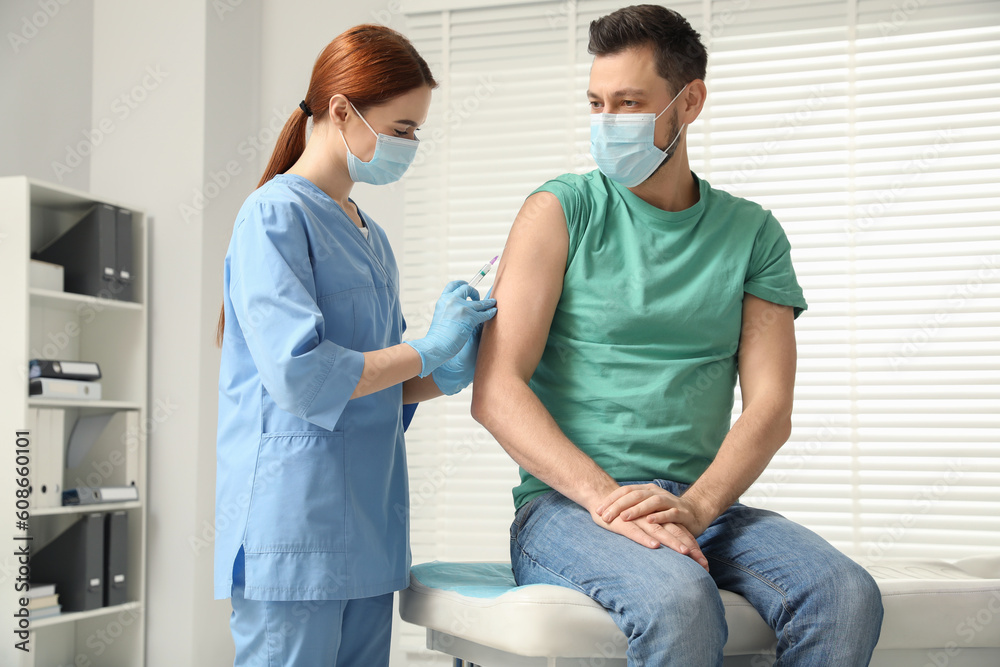 Obraz premium Doctor giving hepatitis vaccine to patient in clinic