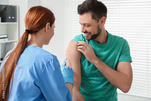 Obraz na plátně Doctor giving hepatitis vaccine to patient in clinic