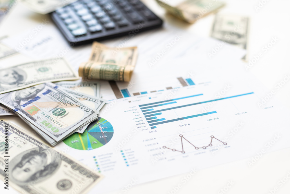 Accounting charts and graphs with us dollar bills pen calculator. Stock market graphs Accounting charts and graphs with us dollar bills pen calculator. Stock market graphs