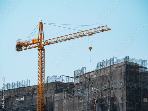 Building under construction, cranes and high-rise building