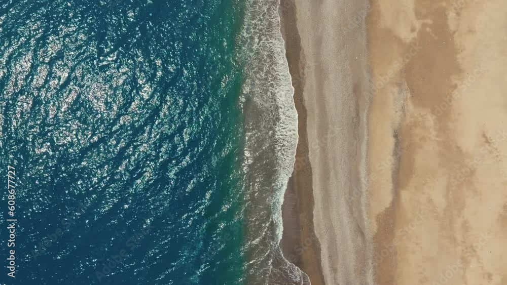 Vertical of a rippling ocean and a golden beach Vertical of a rippling ocean and a golden beach