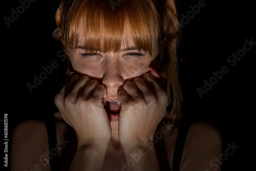 Fototapeta Naklejka Na Ścianę i Meble -  Portrait of scared woman of something in the dark. Closed eyes