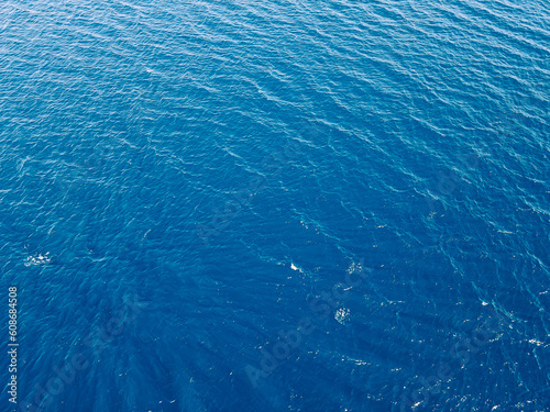 Aerial top down view of sea surface with deep blue water