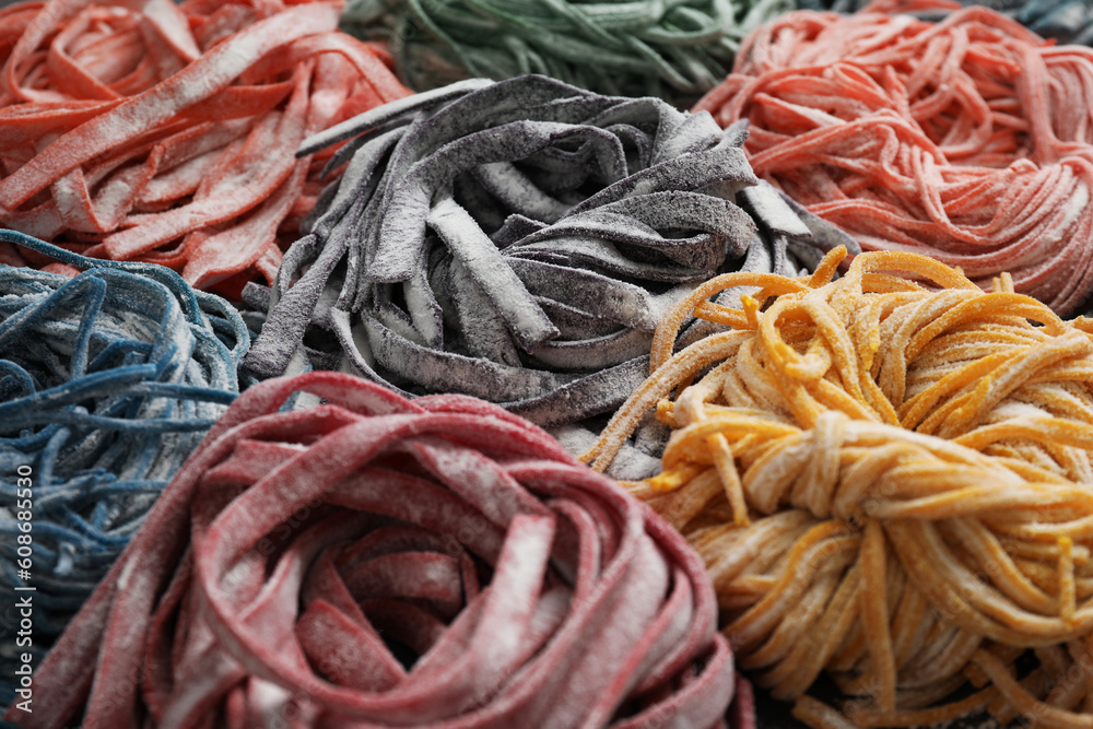 Rolled pasta painted with food colorings as background, closeup Rolled pasta painted with food colorings as background, closeup