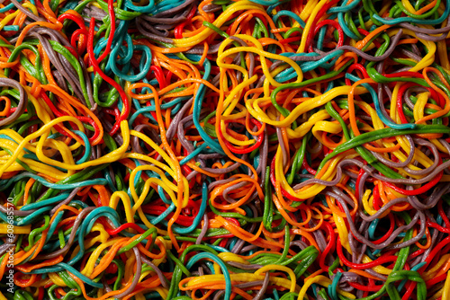 Spaghetti painted with different food colorings as background, top view