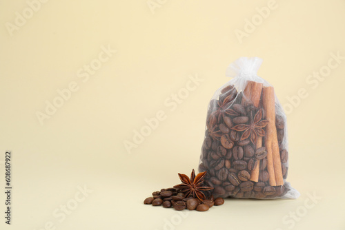 Scented sachet with coffee beans, anise and cinnamon on beige background, space for text