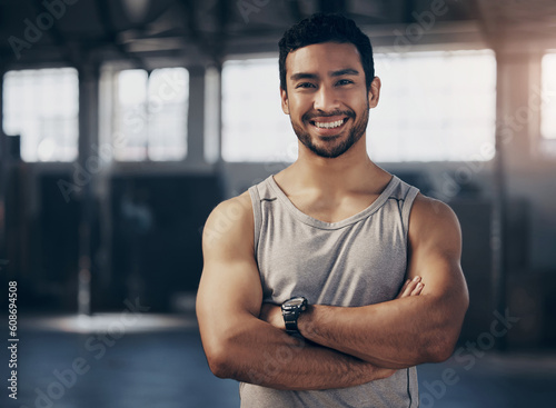 Fitness, smile and portrait of a personal trainer with crossed arms in the gym before a strength workout. Confidence, happy and male athlete after a bodybuilding arm exercise in a sports center.