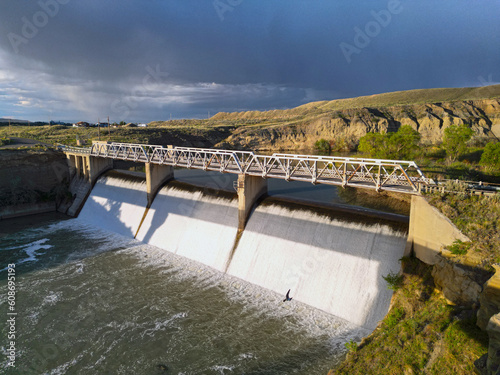 Dam with water flowing down from Shoshone River in Willwood Wyoming with bridge photo