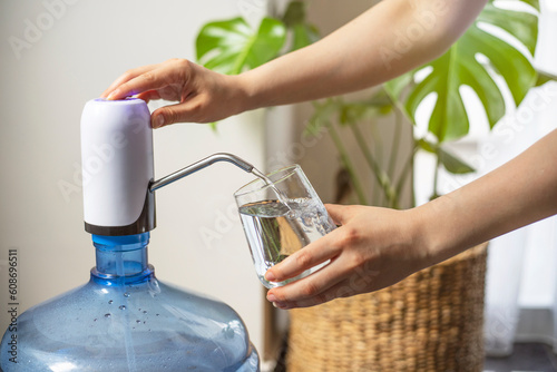 A woman pouring water from water dispenser. Clean and healthy water.