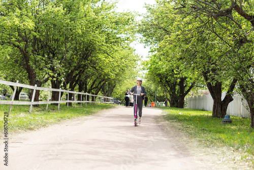 Wallpaper Mural Cute teenager girl riding electric kick scooter in the park Torontodigital.ca
