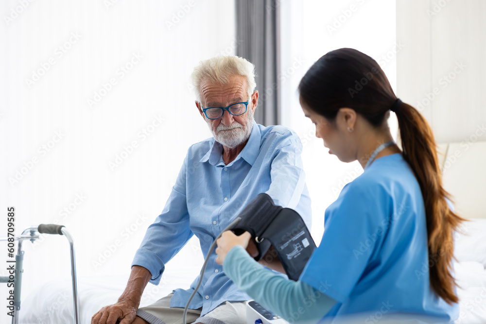 Obraz premium blood pressure gauge. Professional caregiver nursing visit elderly patient at home. Nurse assisting senior patient at nursing home.
