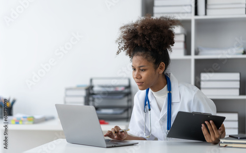 african american woman doctor studying Learn about prescriptions. medical information and all professions in documented information in records and research. researching content on a laptop computer.