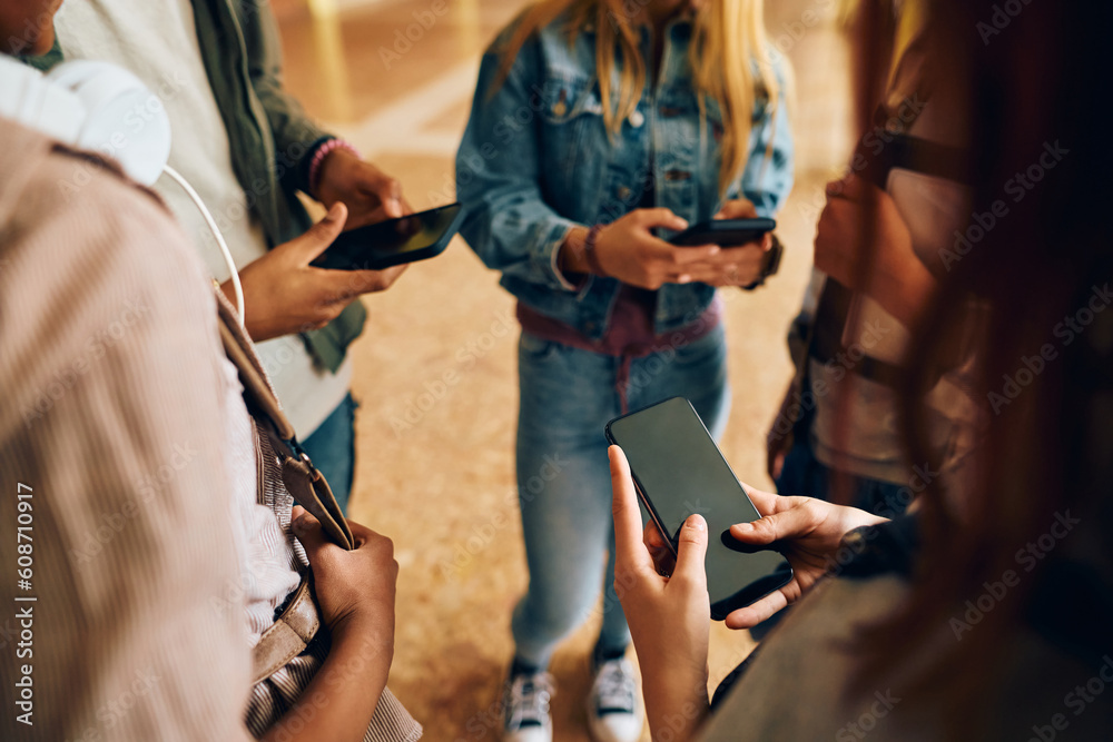 Close up of students using their cell phones in hallway at high school. Close up of students using their cell phones in hallway at high school.