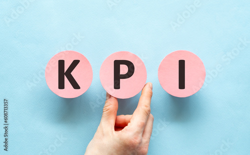 Hand holding pink cards with the word KPI-Key Performance Indicator.