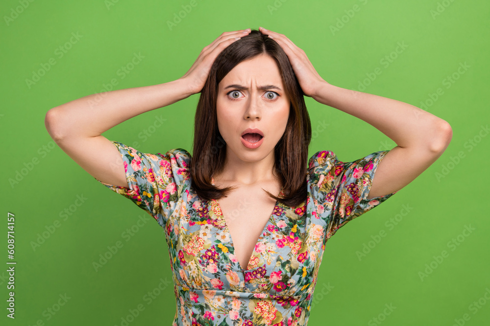 Photo of young attractive lady hands head staring speechless open mouth unhappy her salary decreased isolated on green color background Photo of young attractive lady hands head staring speechless open mouth unhappy her salary decreased isolated on green color background