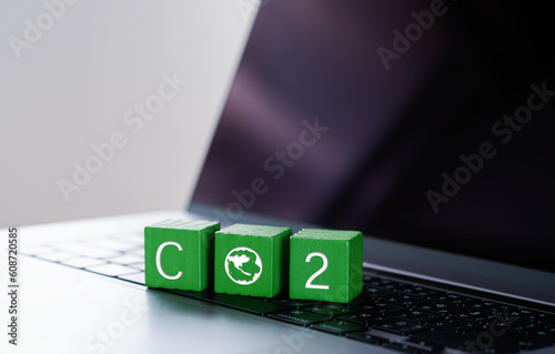 Wooden blocks with CO2 icons placed on laptop. Carbon neutral and net zero concept natural environment Climate-neutral long-term strategy greenhouse gas emissions targets.