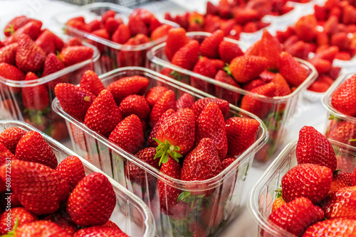 Photos Rows of punnets with ripe fresh strawberries.