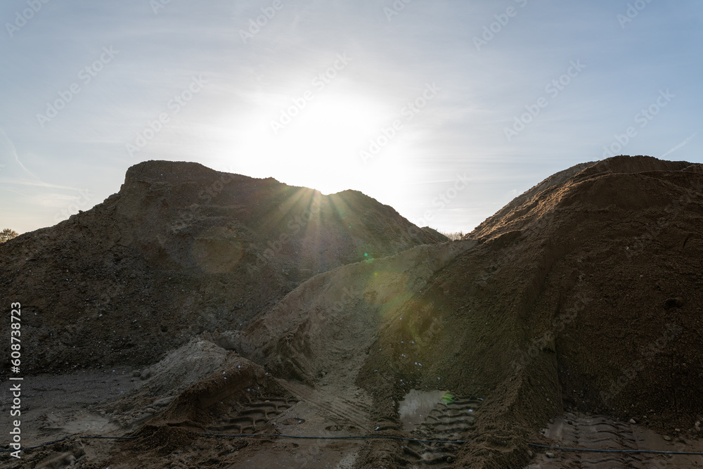 Mountain landscape/ gravel pit.. Sand, rocks and sun at sunset time.