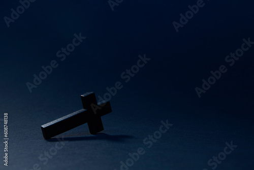 Foto Black wooden traditional cross fallen down and lying on edge at an angle on the