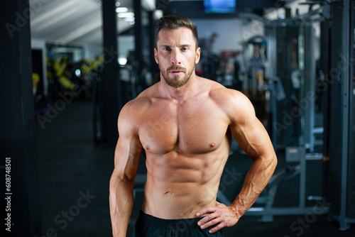 Strong sexy muscular bodybuilder guy in a gym. Concept clouseup,gym, crossfit, bodybuilding.