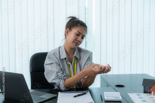 Asian businesswoman having wrist pain when using mouse during working long time on workplace. De Quervain s tenosynovitis, ergonomic, Carpal Tunnel Syndrome or Office syndrome concept photo