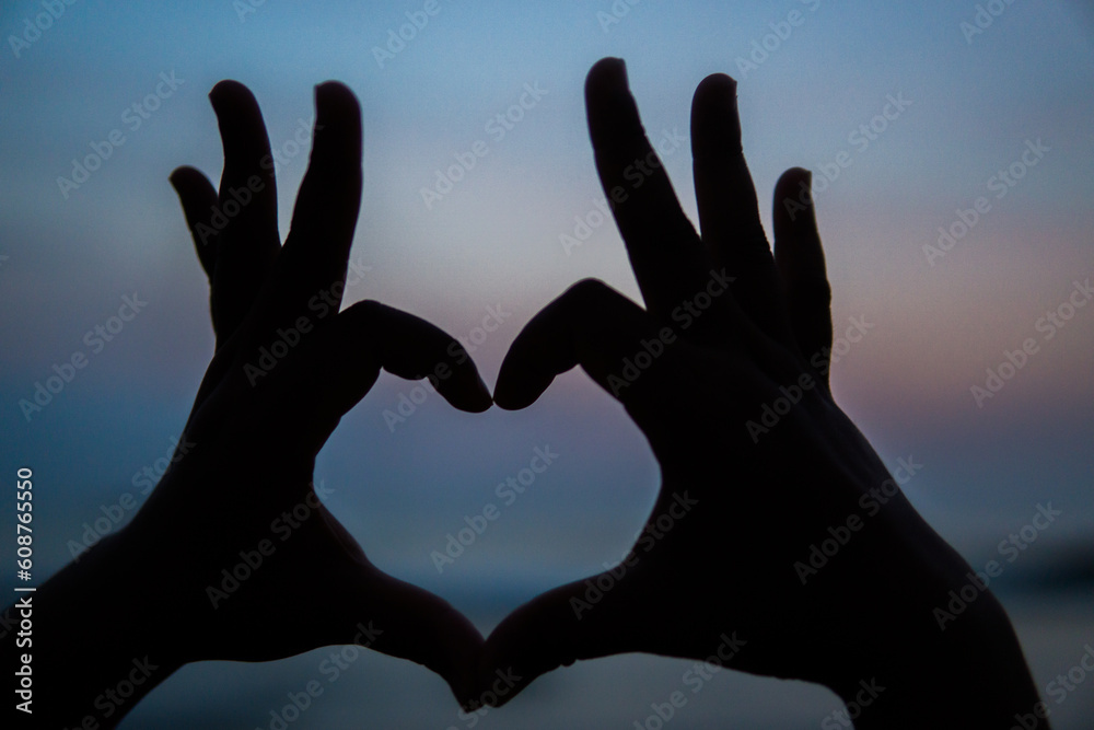 Hands making a heart shape at sunset Hands making a heart shape at sunset
