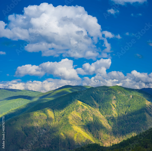 green mountain valley under blue cloudy sky